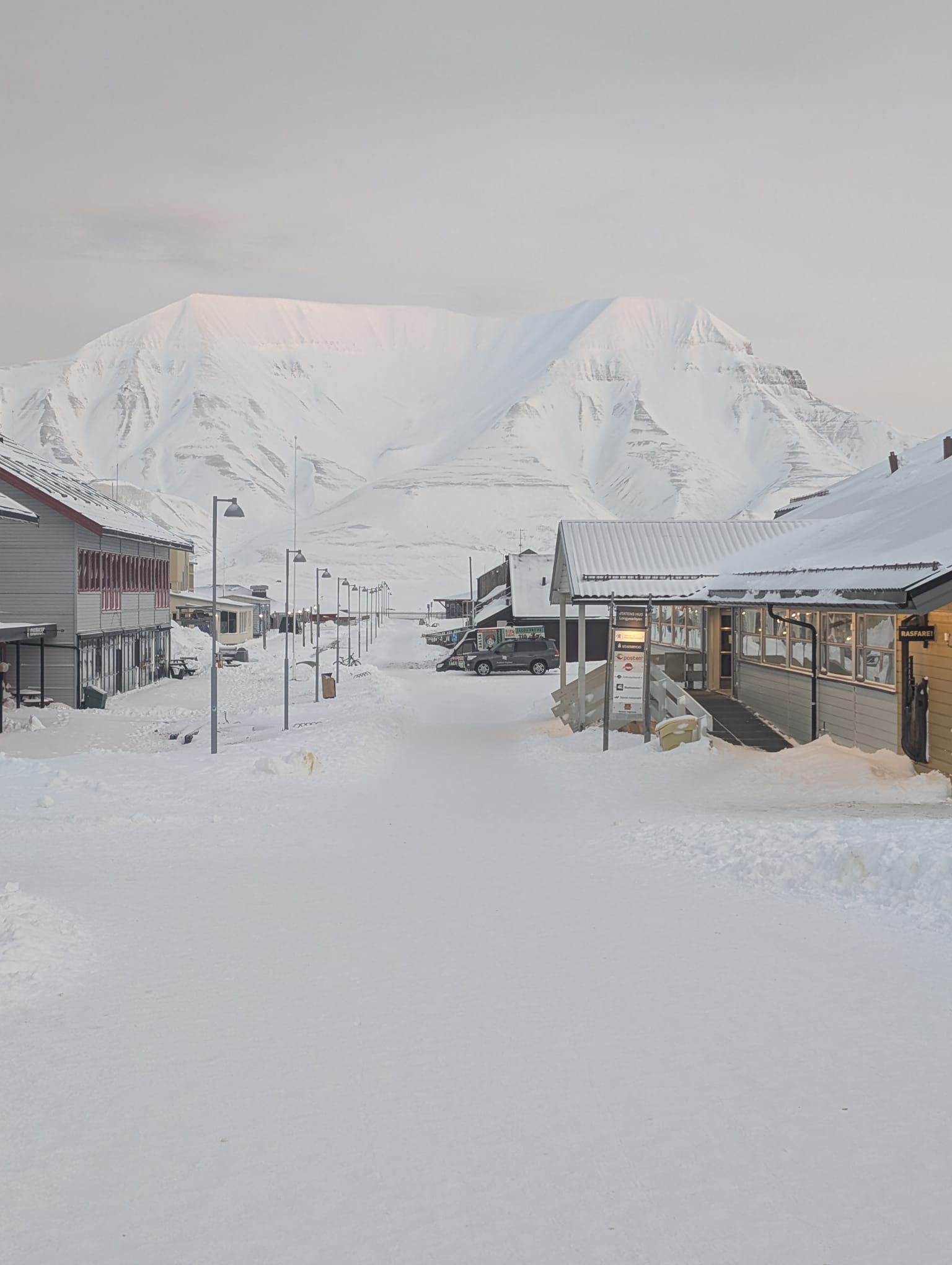 Snow-covered street and mountain backdrop in Longyearbyen, Svalbard