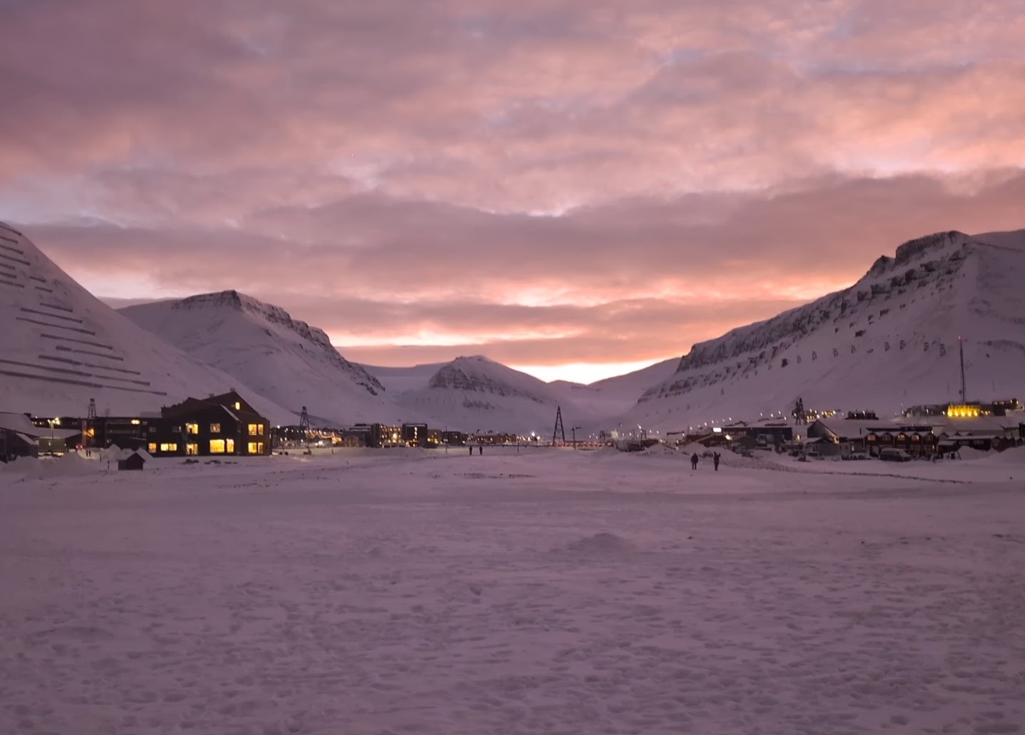 Pink and orange twilight above snow-covered mountains near Longyearbyen, Svalbard